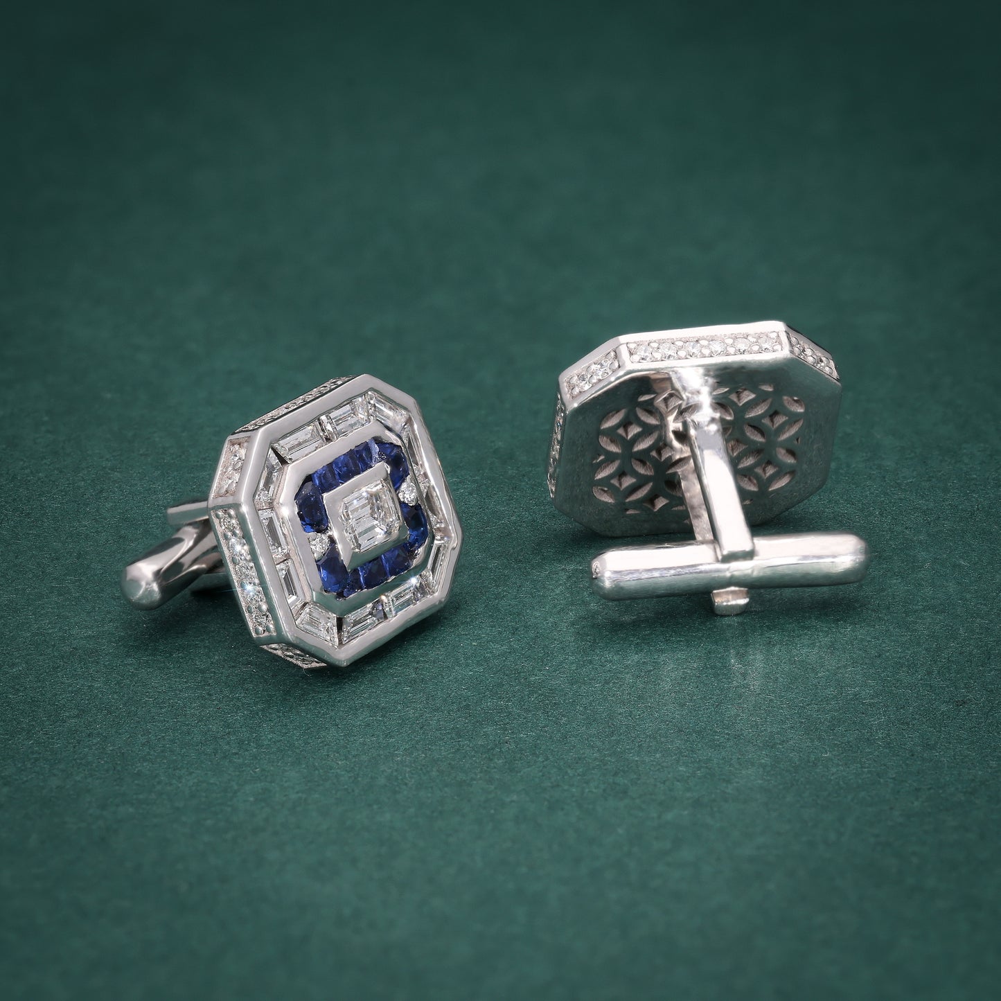 Pair of silver cufflinks with a stunning arrangement of lab-grown diamonds and royal blue accents on a green background