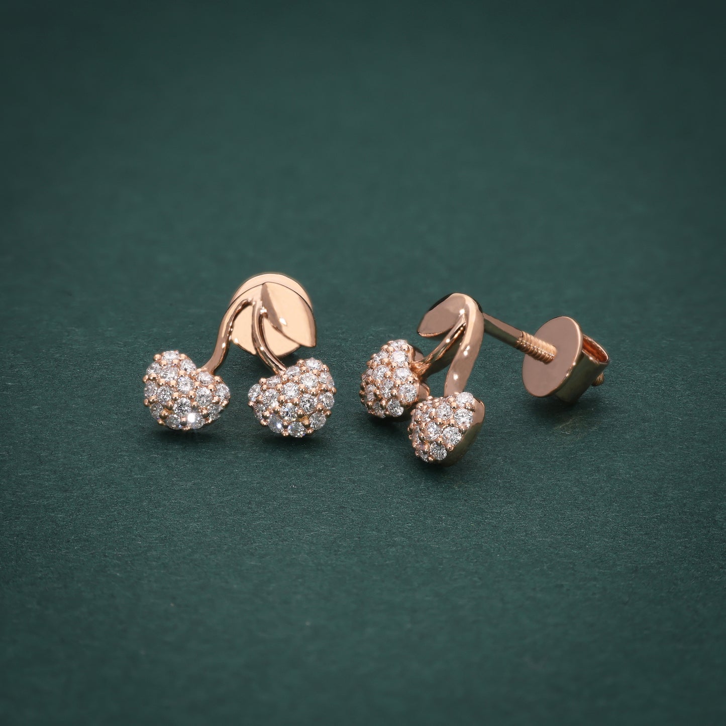 Berry-shaped white gold stud earrings with sparkling lab-grown diamonds, inspired by nature’s charm, displayed on a green background.