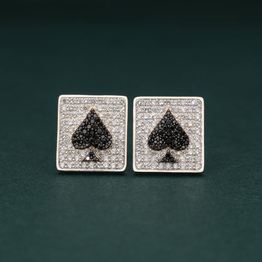 Pair of lab grown diamond cufflinks with spade symbol design on a dark green background