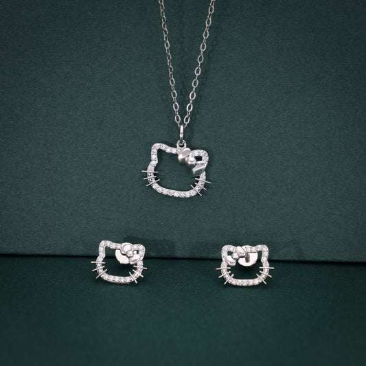 Silver cat-shaped jewelry set with necklace and earrings on a green background