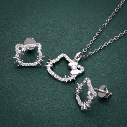 Silver cat-shaped jewelry set with necklace and earrings on a green background