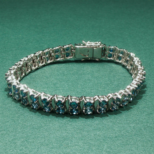 Silver bracelet with blue gemstones on a green background