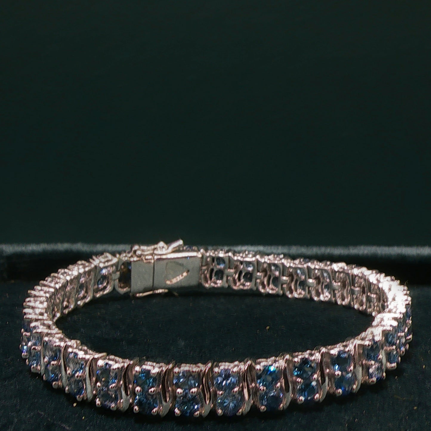 Silver bracelet with blue stones on a dark background