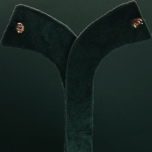 Green velvet garment with gold buttons on a dark green background

