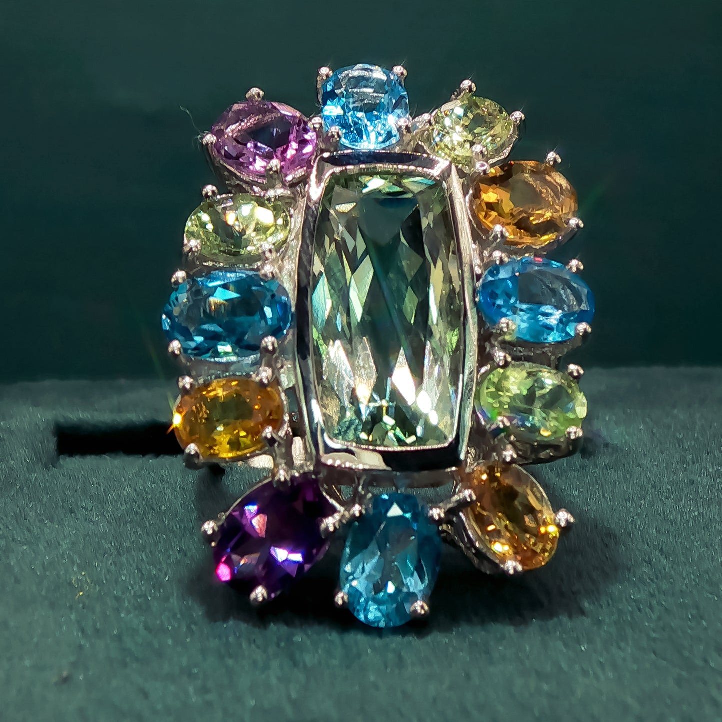 Multicolored gemstone ring on a dark green background
