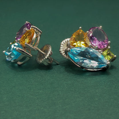 Colorful gemstone earrings on a green background