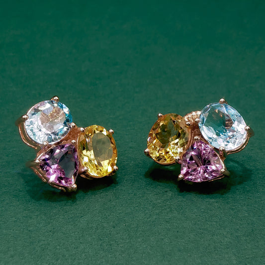Pair of earrings with multicolored gemstones on a green background