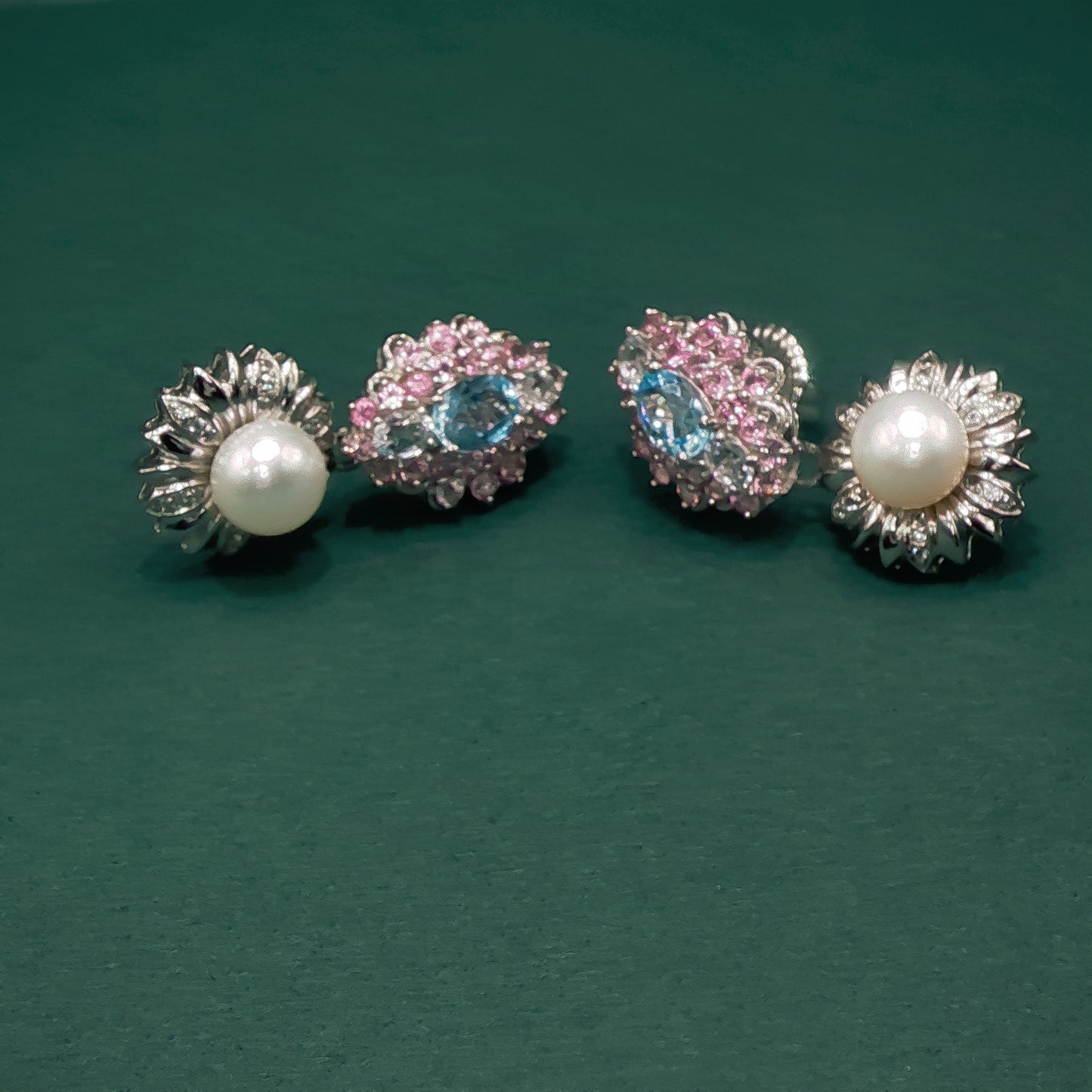 Two pairs of earrings on a green background