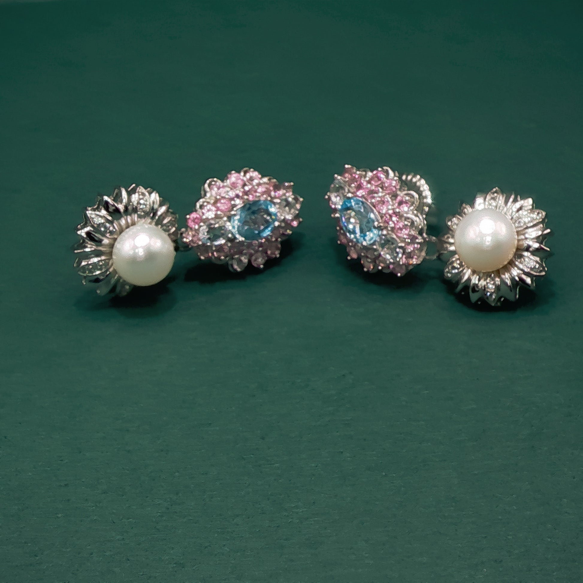 Two pairs of earrings on a green background