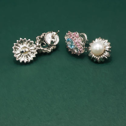 Two pairs of earrings on a green background

