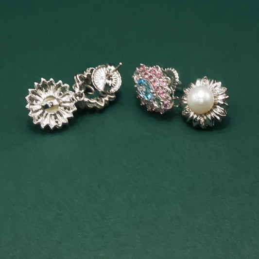 Two pairs of earrings on a green background

