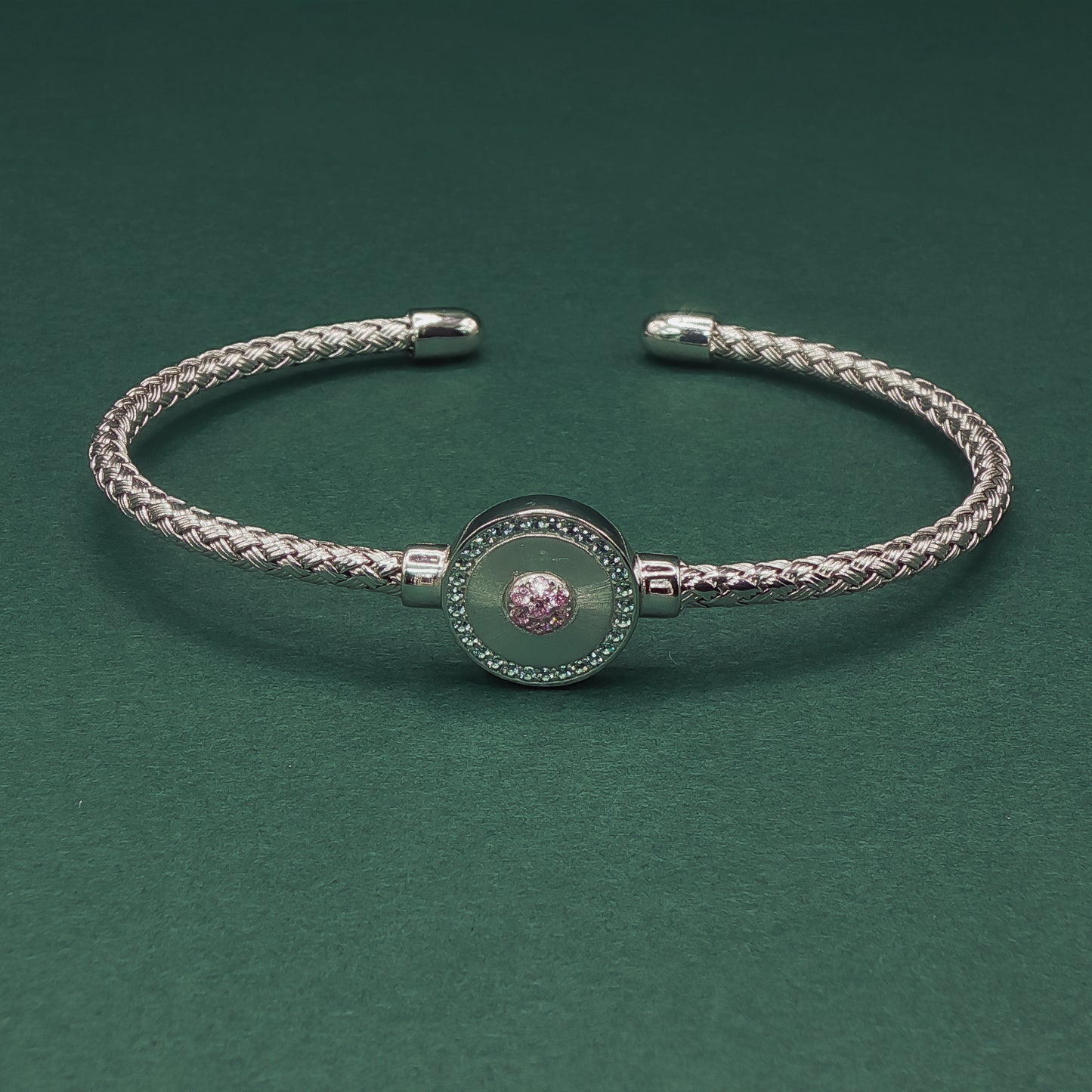 Silver braided bracelet on a dark green background

