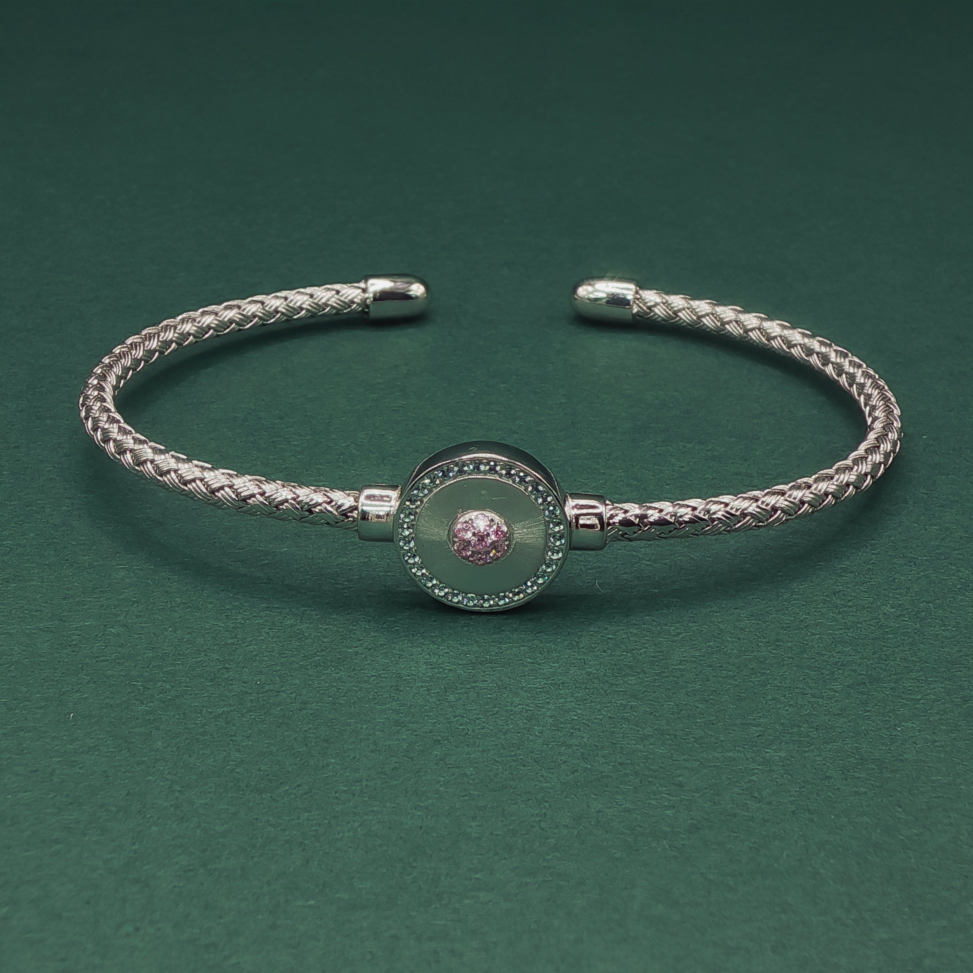Silver braided bracelet on a dark green background


