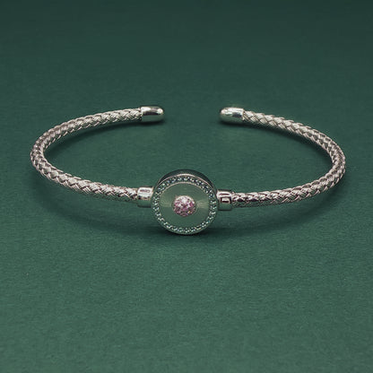 Silver braided bracelet on a dark green background

