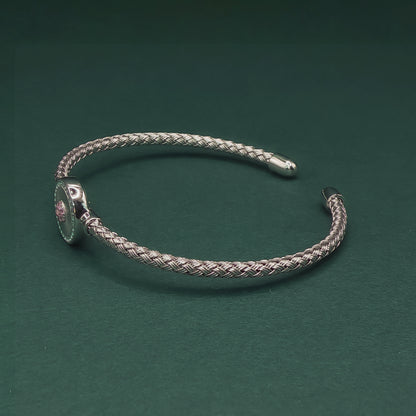 Silver braided bracelet on a dark green background

