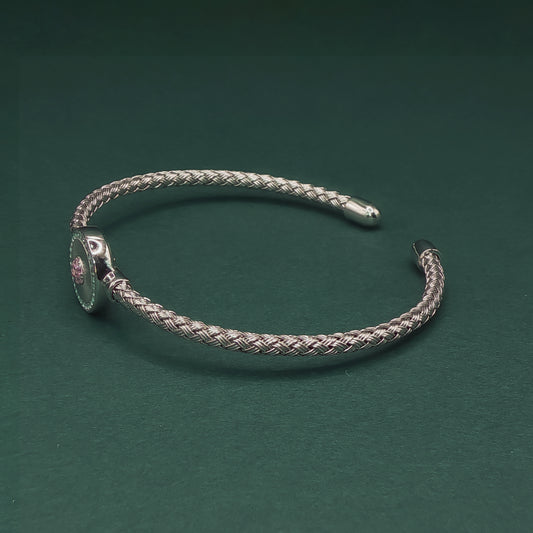 Silver braided bracelet on a dark green background

