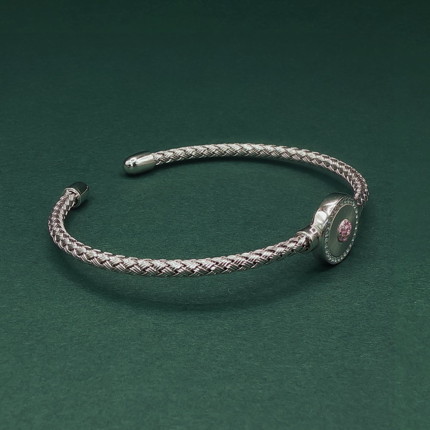 Silver braided bracelet on a dark green background

