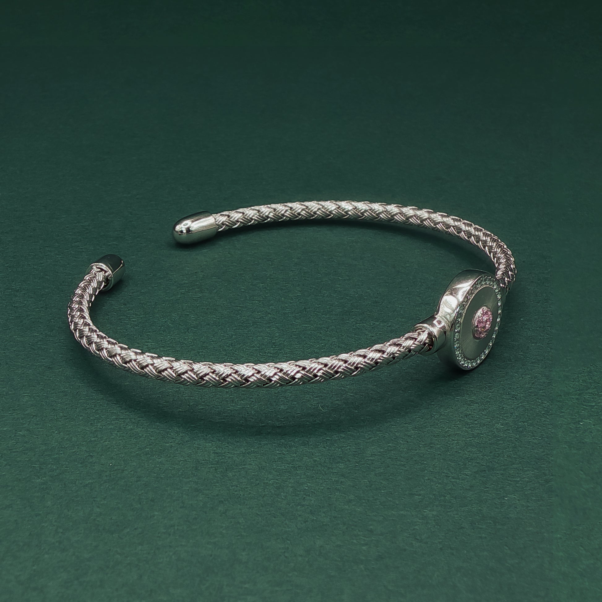 Silver braided bracelet on a dark green background

