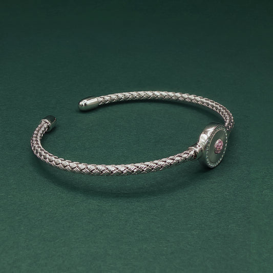 Silver braided bracelet on a dark green background

