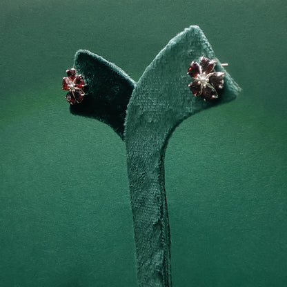 Pair of earrings on a green headband against a green background