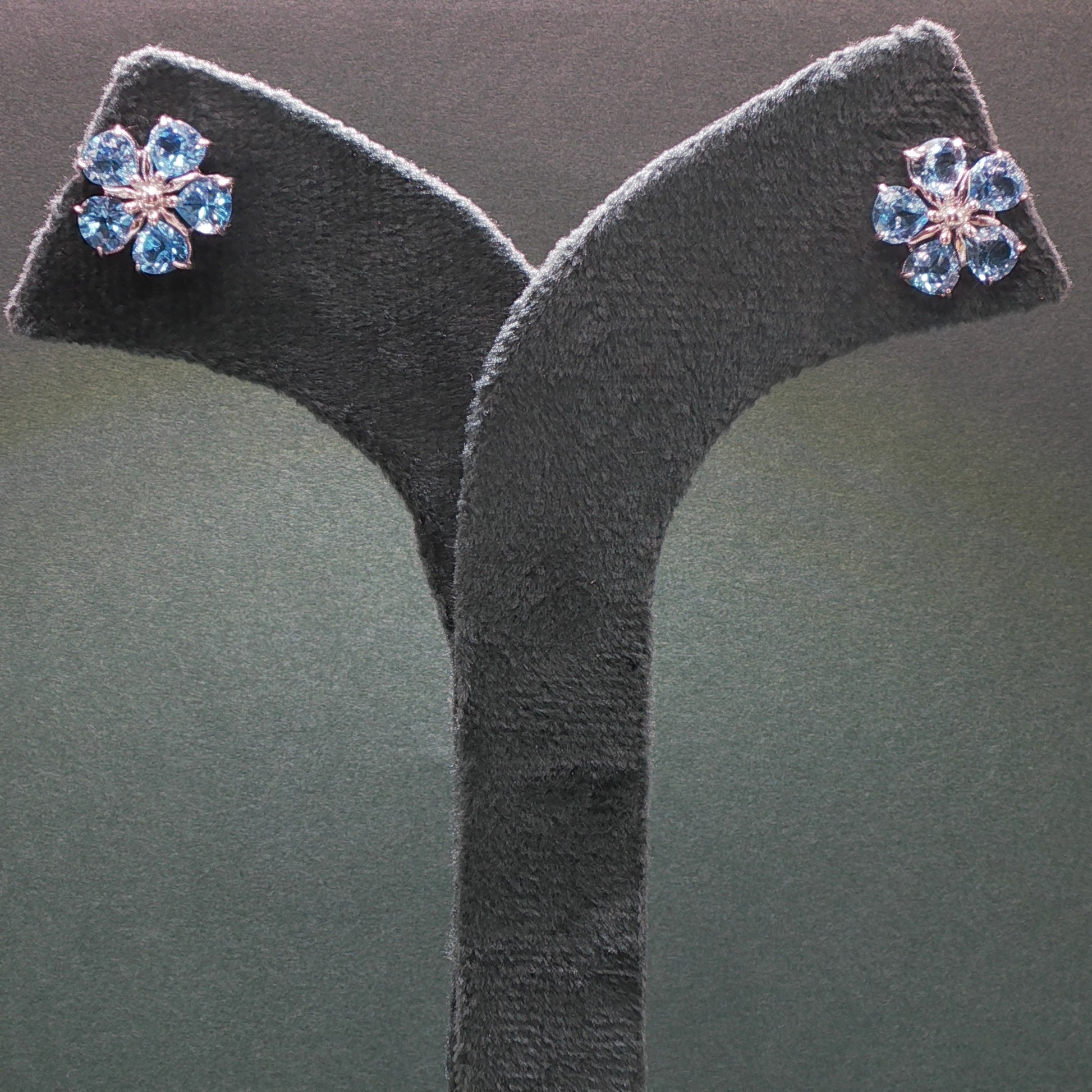 Pair of earrings with blue gemstones on a gray stand