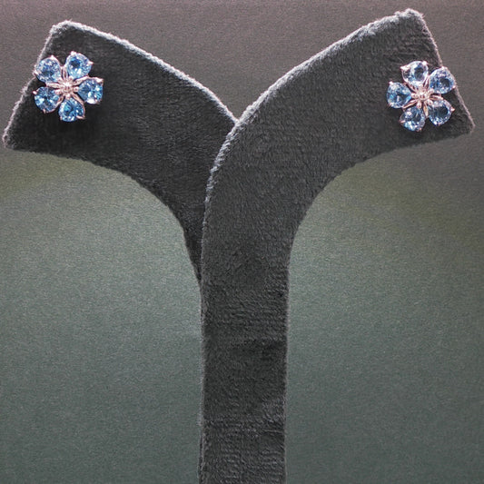 Pair of earrings with blue gemstones on a gray stand
