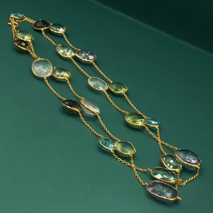 Gold necklace with green gemstones on a green background