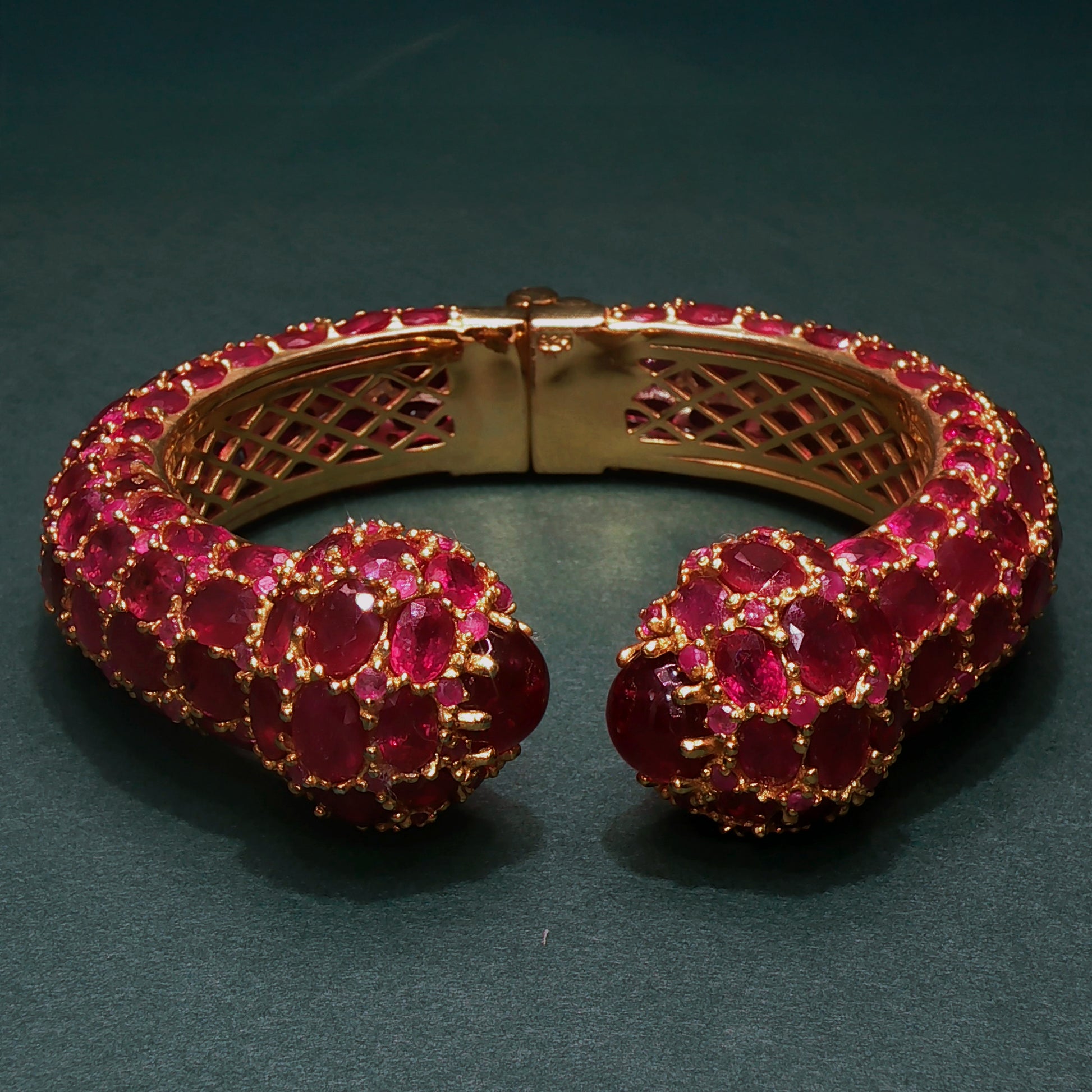 Gold bracelet with red gemstones on a dark background