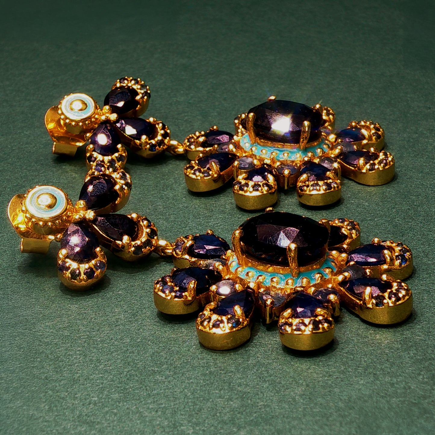 Ornate necklace with purple stones and gold accents on a green background