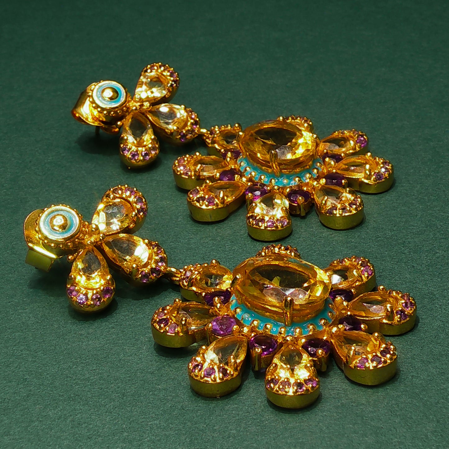 Gold jewelry set with gemstones on a green background