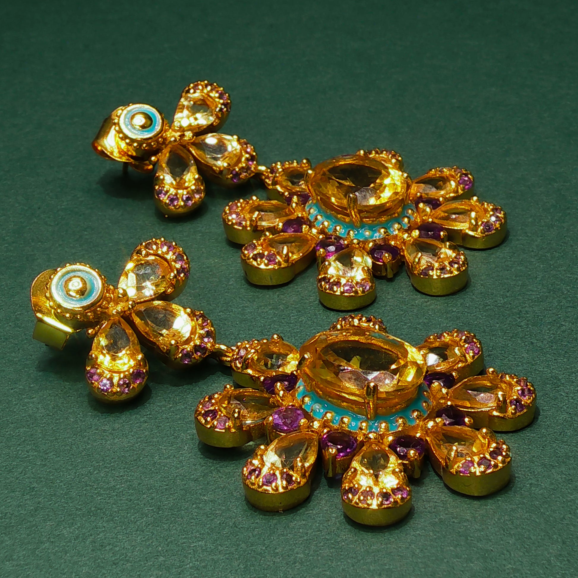 Gold jewelry set with gemstones on a green background