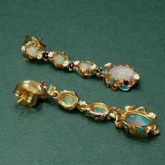 Gold earrings with gemstones on a green background

