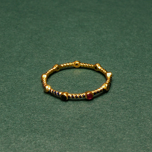 Gold ring with embedded gemstones on a green background