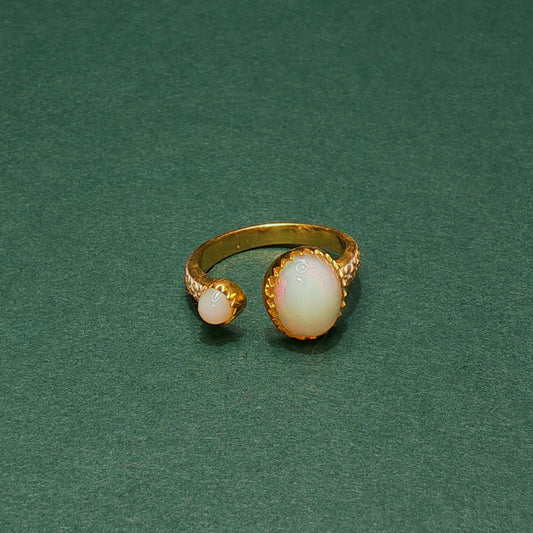Gold ring with opal stones on a green background