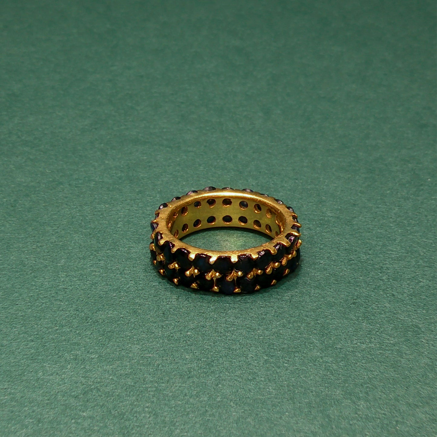 Jewelry ring with embedded stones on a green background

