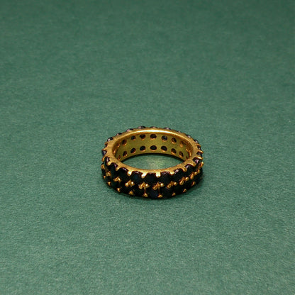 Jewelry ring with embedded stones on a green background

