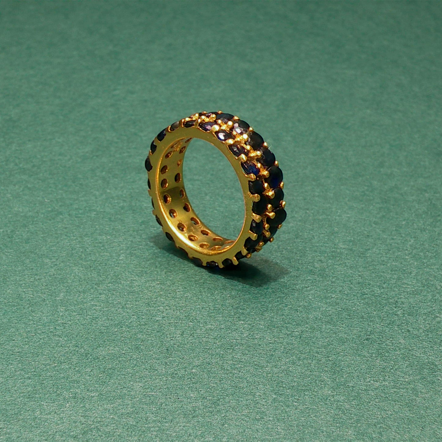 Jewelry ring with embedded stones on a green background

