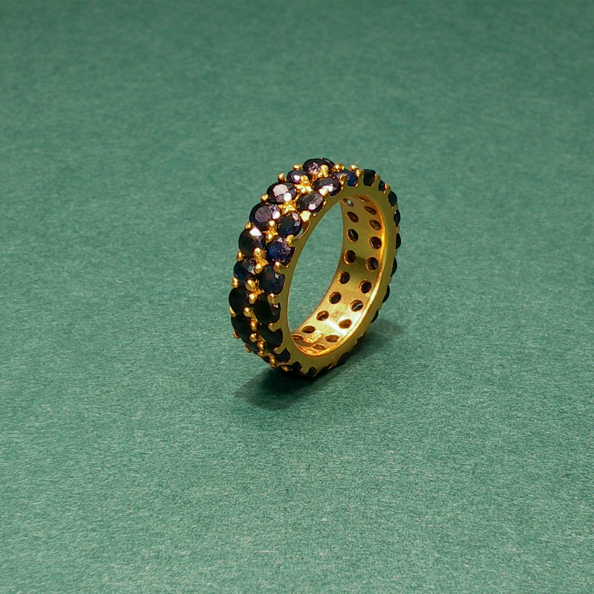 Jewelry ring with embedded stones on a green background

