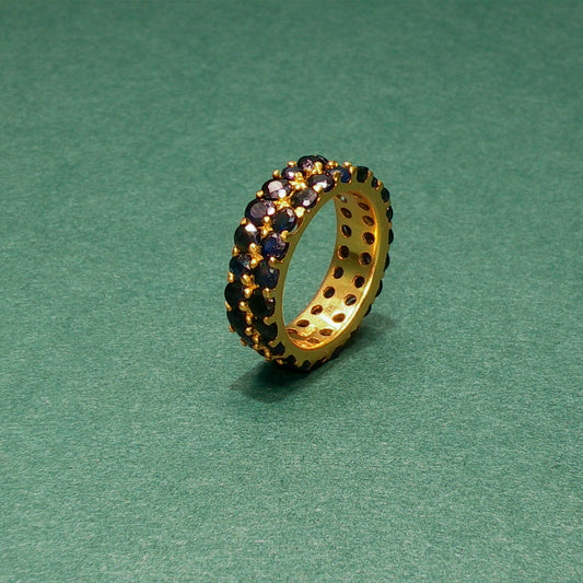 Jewelry ring with embedded stones on a green background

