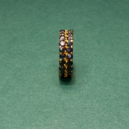 Jewelry ring with embedded stones on a green background

