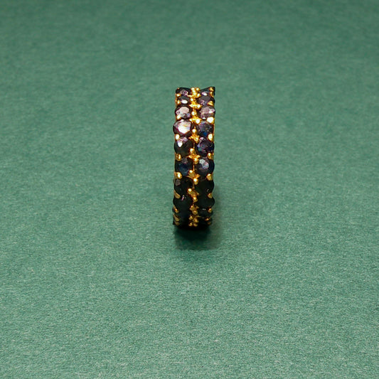 Jewelry ring with embedded stones on a green background

