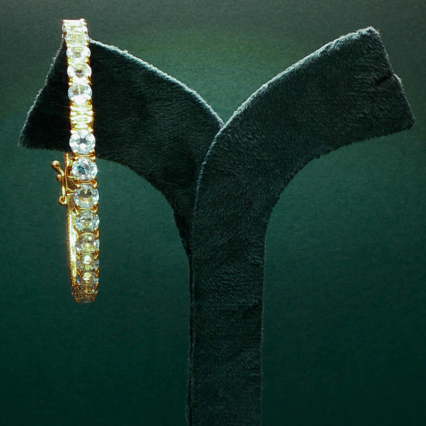Silver bracelet with diamonds on a green stand

